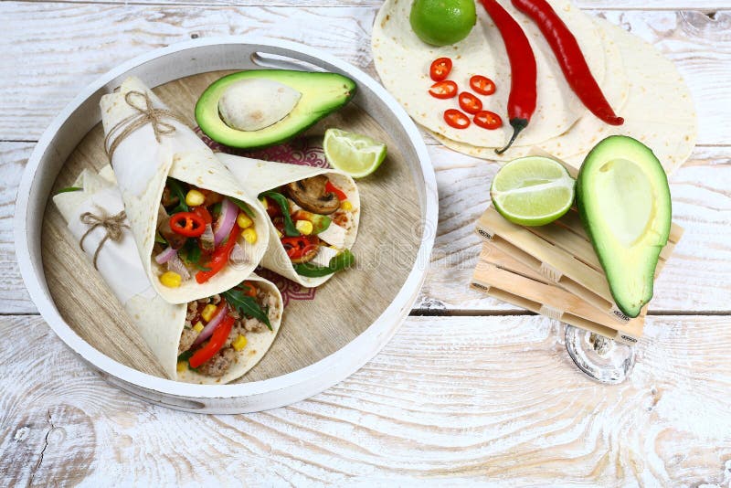Abrigos de los Burritos con el pollo y las verduras en fondo ligero E imágenes de archivo libres de regalías Abrigos de los Burritos con el pollo y las verduras en fondo ligero E imágenes de archivo libres de regalías