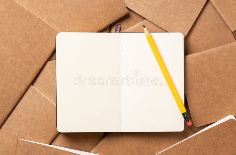 Open notebook with pencil on brown kraft notebook disorder alignment on table background.mockup template for display content or design.content marketing concept. Open notebook with pencil on brown kraft notebook disorder alignment on table background.mockup template for display content or design.content marketing concept.