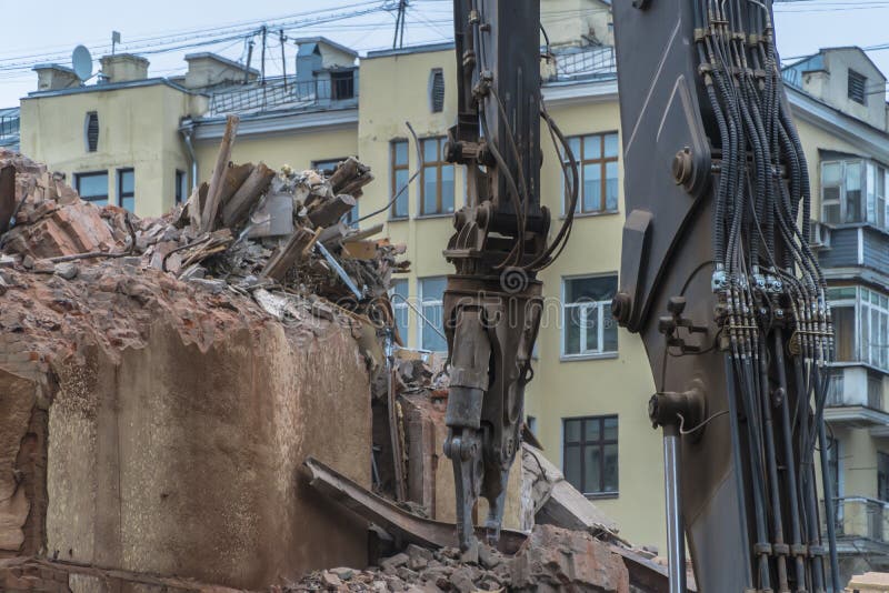 Abriss eines mehrstöckigen Gebäudes mit hydraulischen Scheren für die künftige Entwicklung von Wohngebäuden lizenzfreie stockfotografie Abriss eines mehrstöckigen Gebäudes mit hydraulischen Scheren für die künftige Entwicklung von Wohngebäuden lizenzfreie stockfotografie