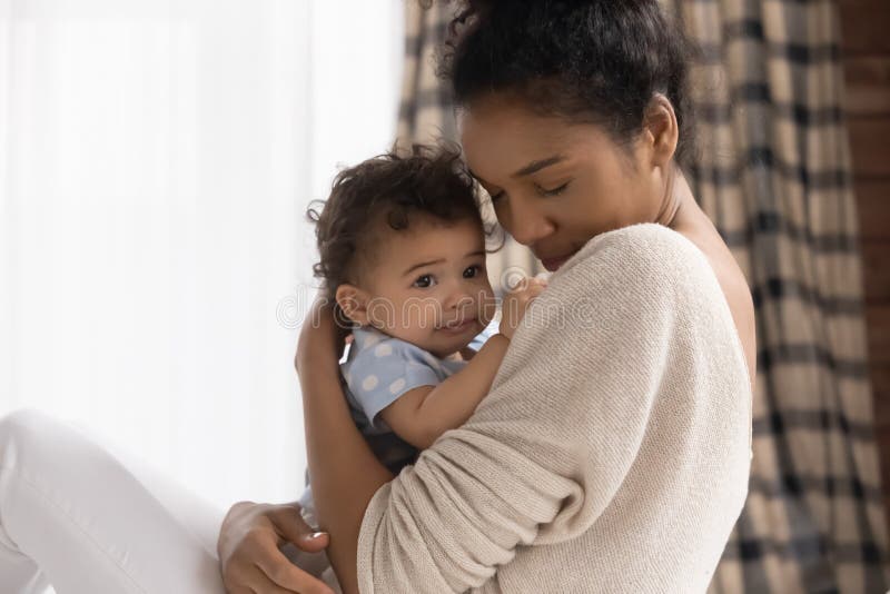 Abschluss in der liebevollen Afroamerikanermutterholding-Kleinkindtochter