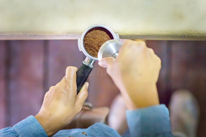 Abschluss herauf Barista drückt gemahlenen Kaffee unter Verwendung des Besetzers stockbild Abschluss herauf Barista drückt gemahlenen Kaffee unter Verwendung des Besetzers stockbild
