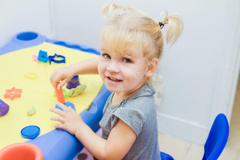 Abschluss herauf Porträt des netten kleinen Kleinkindmädchens formt vom Plasticine auf Tabelle im Spielraum Kinderkreativität Kin stockfoto Abschluss herauf Porträt des netten kleinen Kleinkindmädchens formt vom Plasticine auf Tabelle im Spielraum Kinderkreativität Kin stockfoto