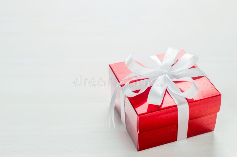 Abschluss oben der roten Geschenkbox mit weißem Bandbogen auf weißem backgrou stockfoto Abschluss oben der roten Geschenkbox mit weißem Bandbogen auf weißem backgrou stockfoto