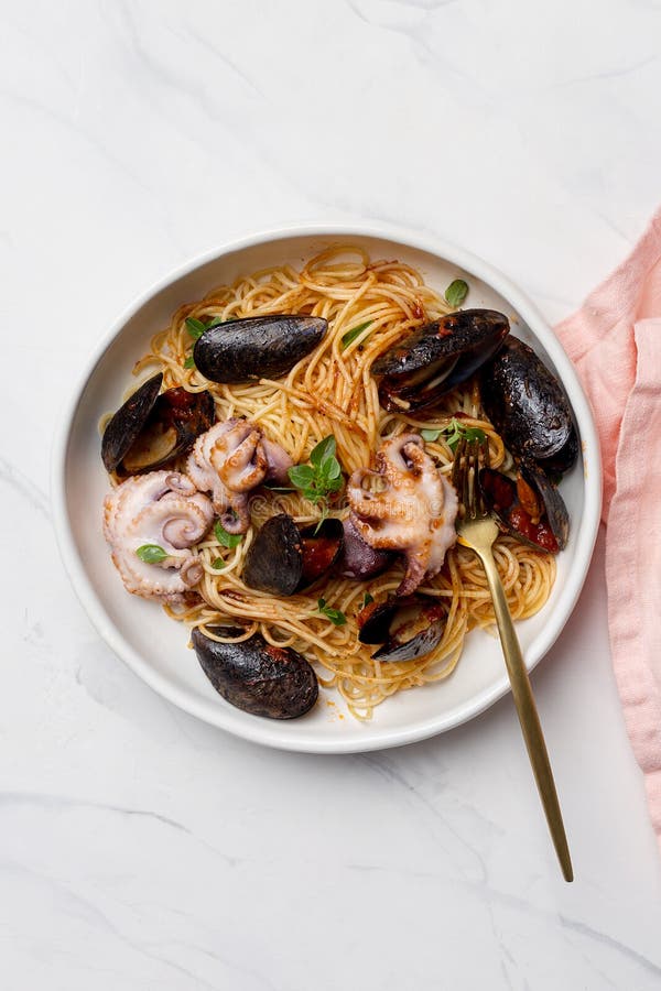 Abschluss oben Makkaroni mit Krake und Tomatensauce Spaghettis mit Krake und Miesmuscheln in der weißen Schüssel lizenzfreies stockbild Abschluss oben Makkaroni mit Krake und Tomatensauce Spaghettis mit Krake und Miesmuscheln in der weißen Schüssel lizenzfreies stockbild