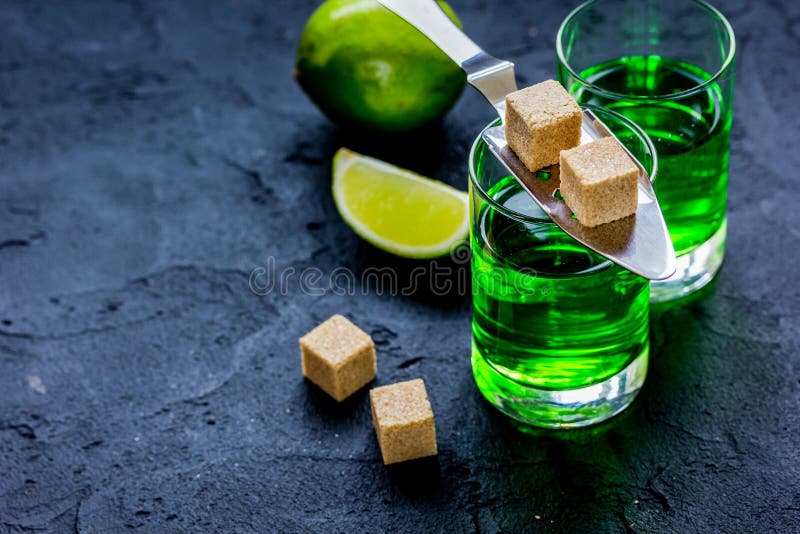 Absinthe shots with lime slices and sugar on dark table background mock-up