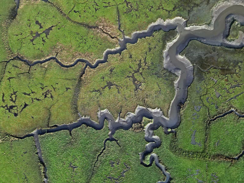 Abstract aerial view of river flow and marshland at River Test delta