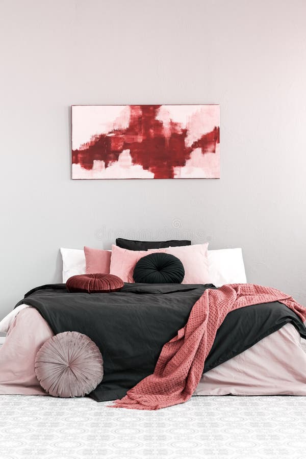 Abstract amaranth and pastel pink painting above king size bed with pink and black bedding royalty free stock photography Abstract amaranth and pastel pink painting above king size bed with pink and black bedding royalty free stock photography