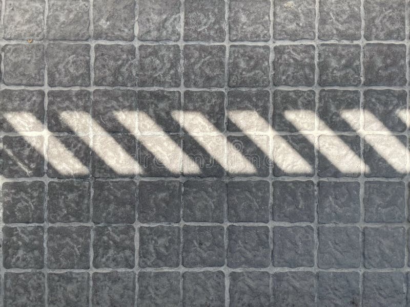 Abstract background : Light and Shadow on grey concrete blocks floor. stock photo