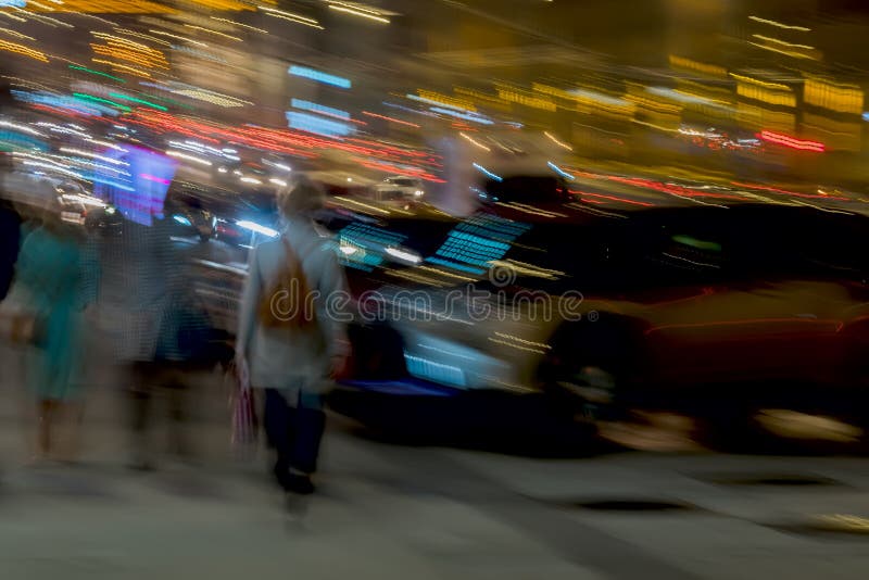 Abstract background. Street, girl with a backpack back to us and other people Near the parking lot, motion blur. Concept