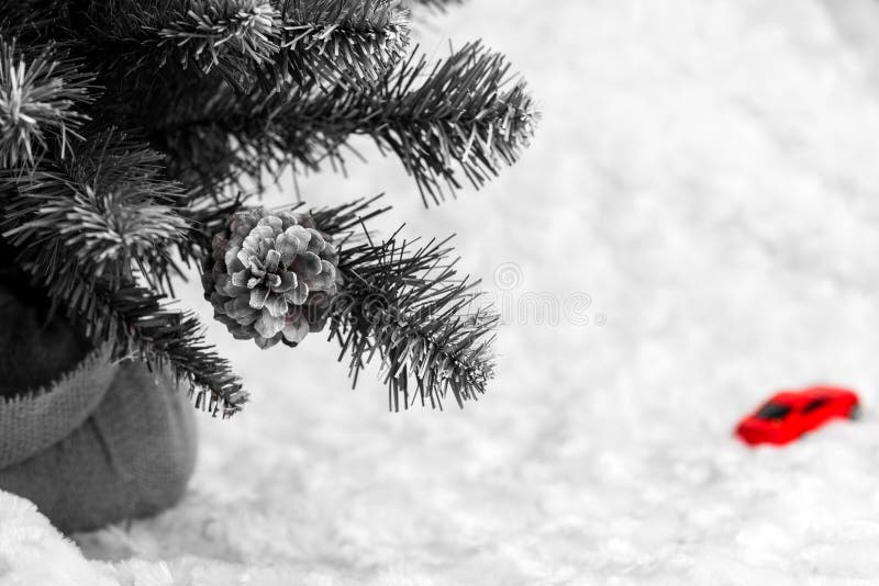 Abstract black and white photo with red fragment. A fragment of an artificial Christmas tree on a blurred background and a toy red royalty free stock images Abstract black and white photo with red fragment. A fragment of an artificial Christmas tree on a blurred background and a toy red royalty free stock images