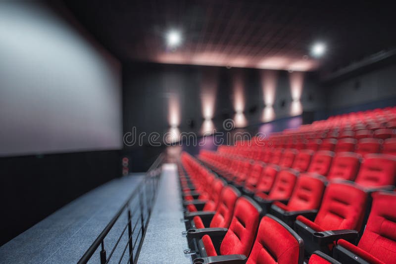 Abstract blur Empty rows of red theater or movie seats. Chairs in cinema hall. Comfortable armchair