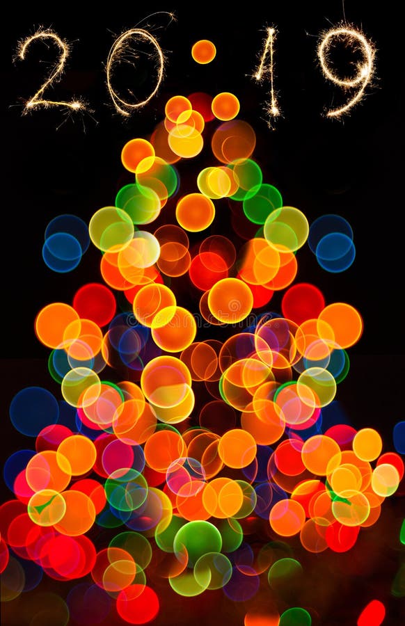 Abstract circular bokeh background of Christmas tree ight and 2019 year wrote with sparkler fireworks stock photography Abstract circular bokeh background of Christmas tree ight and 2019 year wrote with sparkler fireworks stock photography
