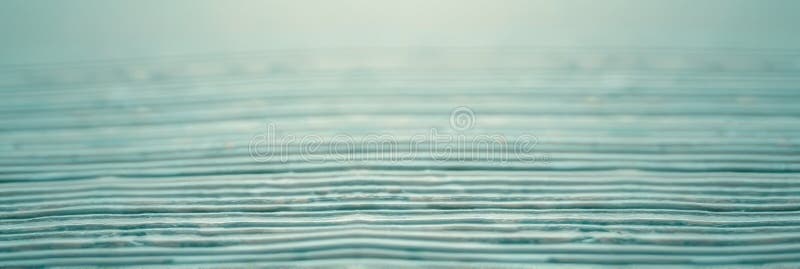 Abstract close-up of layered patterned surface with soft blue hue. That the image is generated using AI.