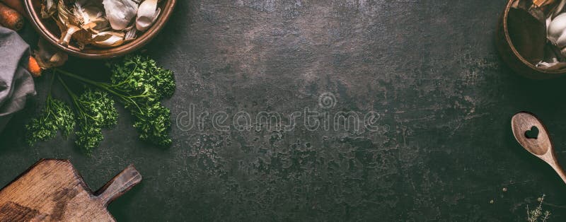 Abstract food background. Top view of dark rustic kitchen table with wooden cutting board and cooking spoon, frame. Banner or