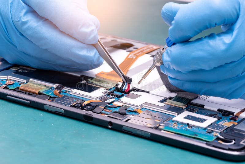 The abstract image of the asian technician assembling inside of tablet by screwdriver in the lab. stock photos