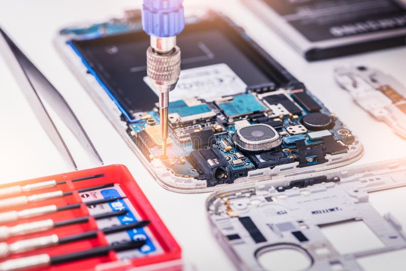 The abstract image of the technician assembling inside of smartphone by screwdriver in the lab. royalty free stock images