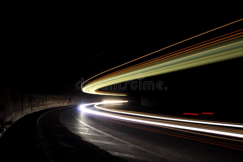 Abstract lights in a car tunnel in white, green, orange