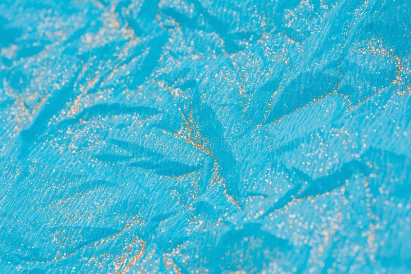 Abstract macro blue crumpled paper background with gold glitter royalty free stock photos