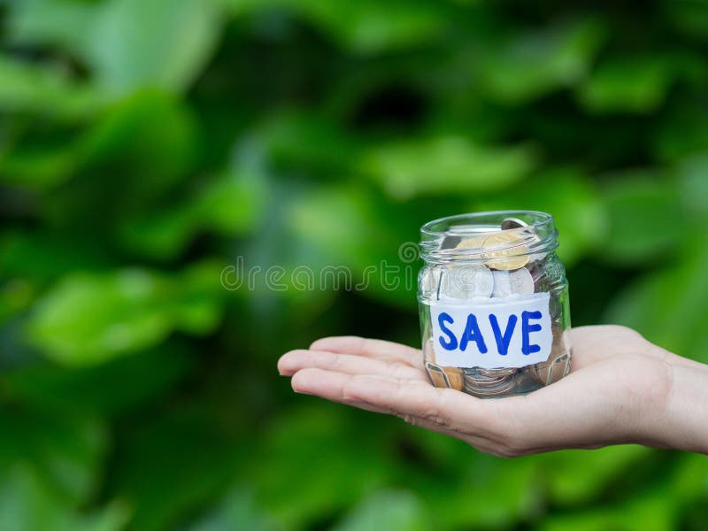 Abstract money saving hand hold a glass jar