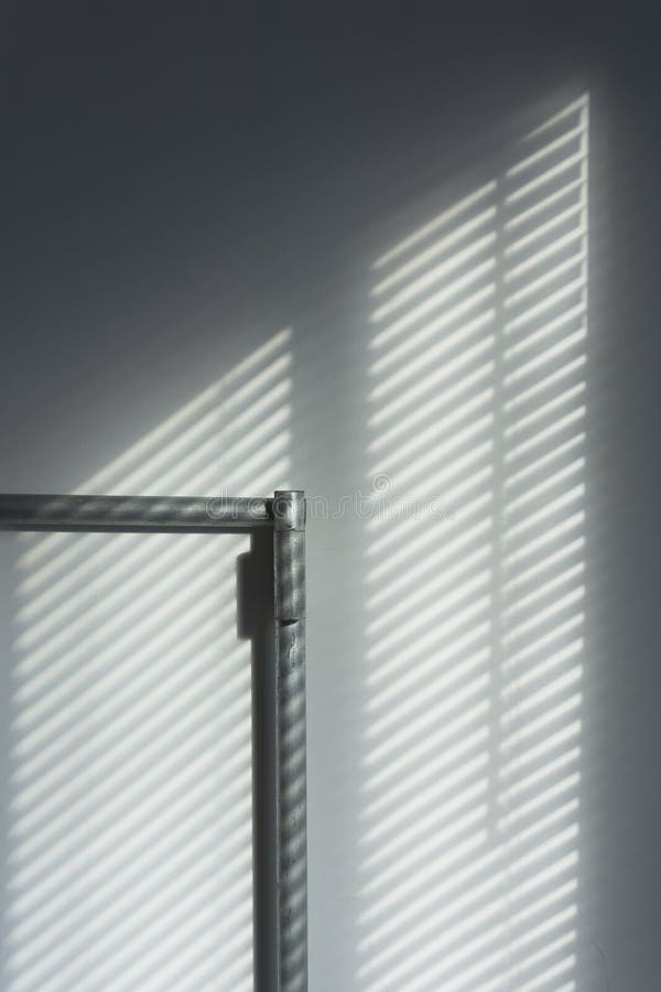 Abstract Of Morning Light And Shadow On Wall Through Window Blind