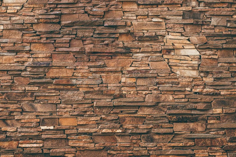 Abstract pattern of brown stone texture. Brick wall background. Rough granite surface. Cracked rock. Decorative tile on facade of royalty free stock photo