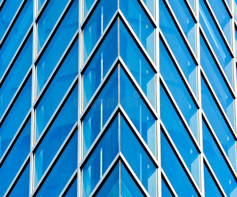 Abstract pattern of modern glass windows building with reflection from building skyscrapers of business center in the city.