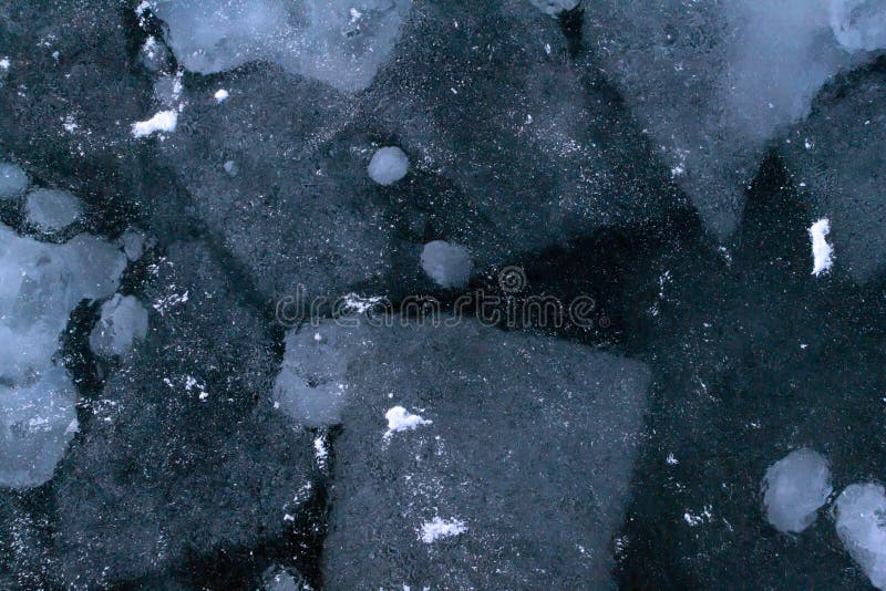 Abstract texture of broken and re-frozen white ice with air bubbles at winter sea.