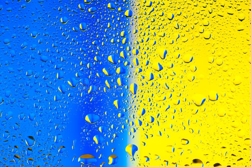 Abstract texture. Water drops on glass with blue and yellow background stock photo
