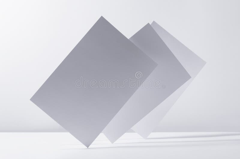 Abstract white grey minimalist background with flying papers in light with shadow as blank copy space. stock image