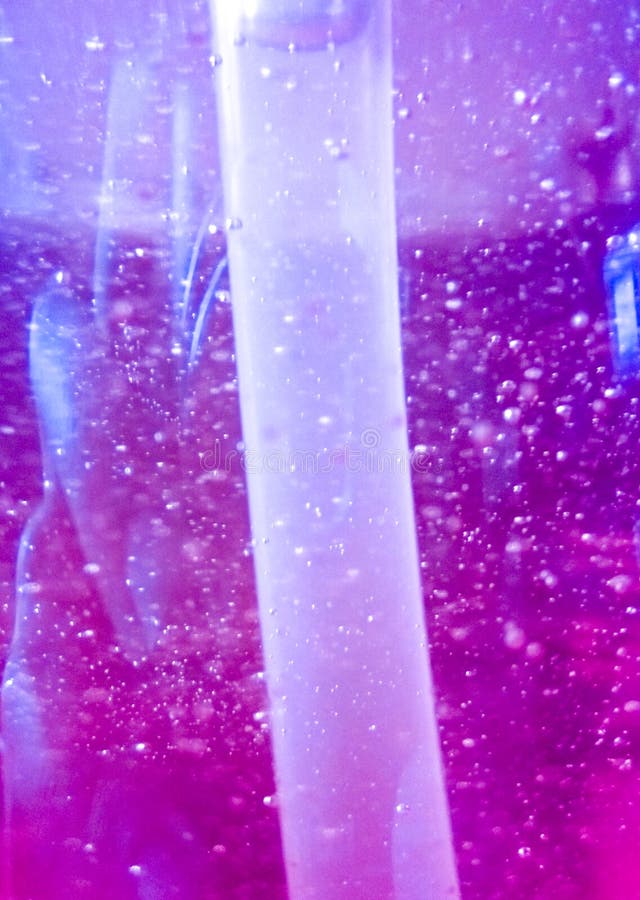 Abstracte achtergrond met luchtbellen binnen de purper-oranje vloeistof van de schotelzeep met plastic buis royalty-vrije stock foto Abstracte achtergrond met luchtbellen binnen de purper-oranje vloeistof van de schotelzeep met plastic buis royalty-vrije stock foto