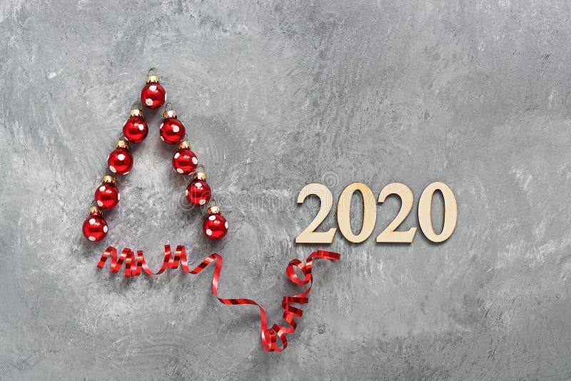 Abstracte kerstboom gemaakt van rode kerstballen en linten op een grijze, betonnen rustige achtergrond Nieuwjaar 2020 stock foto Abstracte kerstboom gemaakt van rode kerstballen en linten op een grijze, betonnen rustige achtergrond Nieuwjaar 2020 stock foto