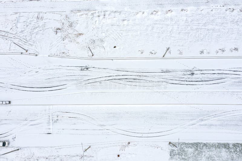 Abstrakte Vogelperspektive der schneebedeckten Straße mit Reifenbahnen Winterhintergrund stockbilder