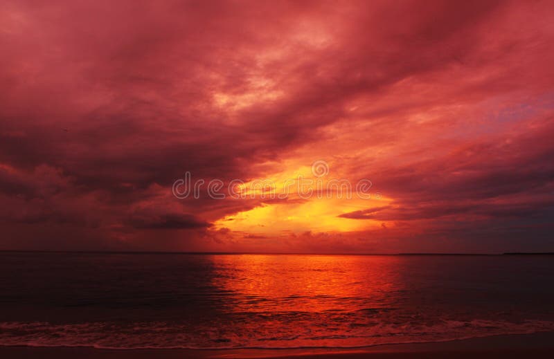 Abstrakter Hintergrund färbt Feuer im Himmelsommersonnenuntergang über Meer