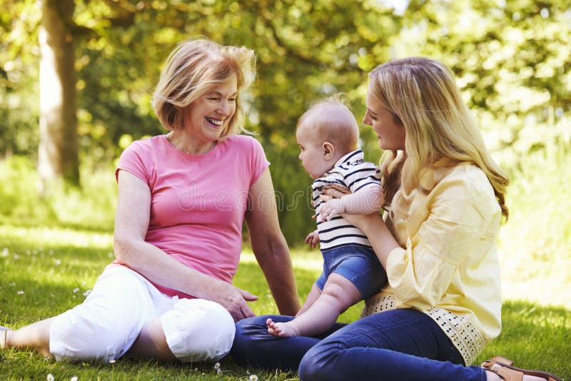 Abuela y madre que juegan con el hijo del bebé al aire libre en jardín fotografía de archivo libre de regalías Abuela y madre que juegan con el hijo del bebé al aire libre en jardín fotografía de archivo libre de regalías