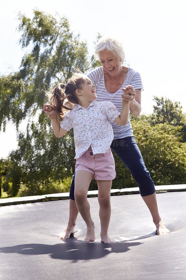 Abuela y nieta que despiden en el trampolín imagen de archivo libre de regalías Abuela y nieta que despiden en el trampolín imagen de archivo libre de regalías