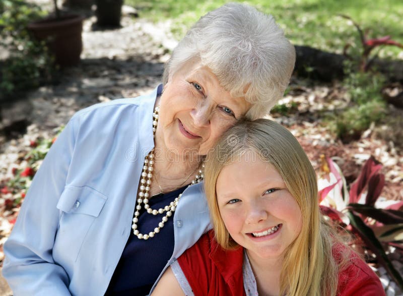 A portrait of a grandmother and granddaughter in the garden. Horizontal composition with room for text. A portrait of a grandmother and granddaughter in the garden. Horizontal composition with room for text.