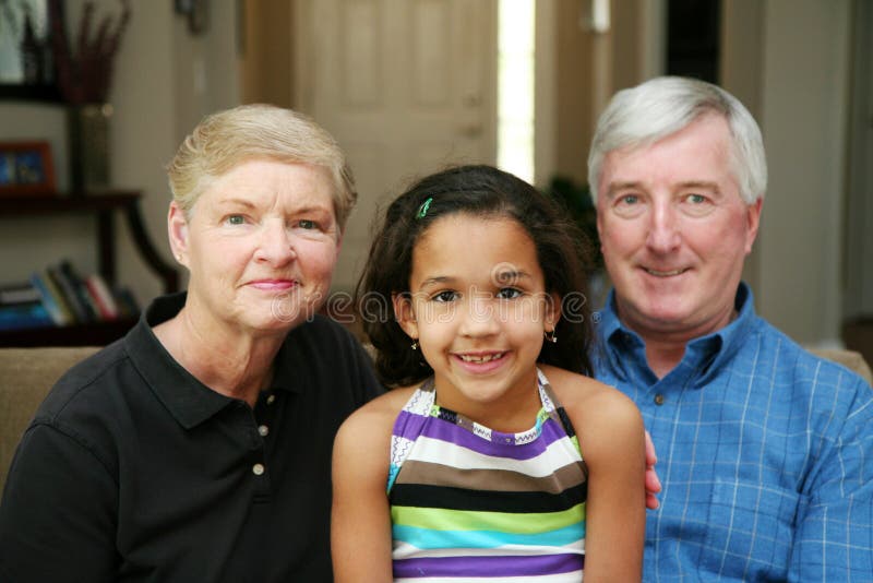 Senior couple together in their home with their granddaughter. Senior couple together in their home with their granddaughter