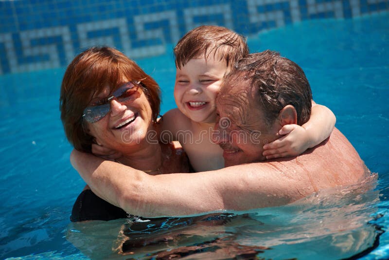 Happy family: grandparents having bath in pool together with grandson (3 years), smiling, outdoor, summer. Happy family: grandparents having bath in pool together with grandson (3 years), smiling, outdoor, summer.