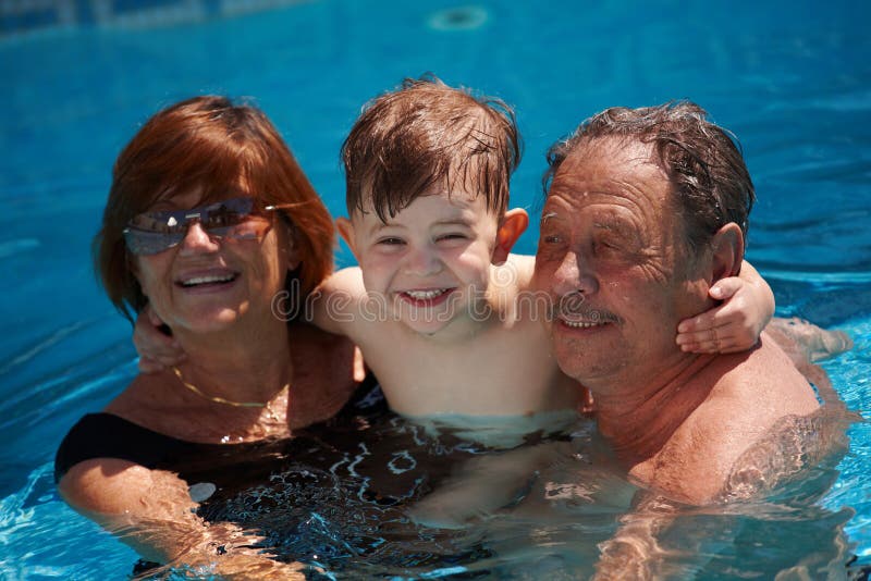 Happy family: grandparents having bath in pool together with grandson (3 years), smiling, outdoor, summer. Happy family: grandparents having bath in pool together with grandson (3 years), smiling, outdoor, summer.