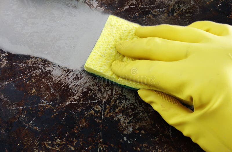 Cleaning a greasy pan with yellow latex gloves. Cleaning a greasy pan with yellow latex gloves