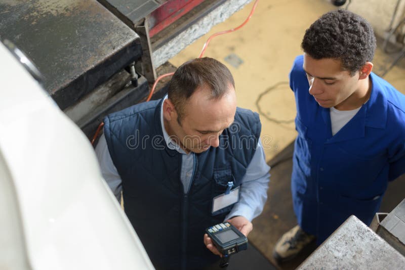 Abwärts Arbeitskräfte der Ansicht zwei ein haltenes elektronisches Gerät lizenzfreies stockbild Abwärts Arbeitskräfte der Ansicht zwei ein haltenes elektronisches Gerät lizenzfreies stockbild