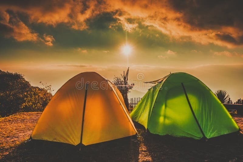 Acampamento e barracas na zona alta com por do sol do nascer do sol fotografia de stock Acampamento e barracas na zona alta com por do sol do nascer do sol fotografia de stock