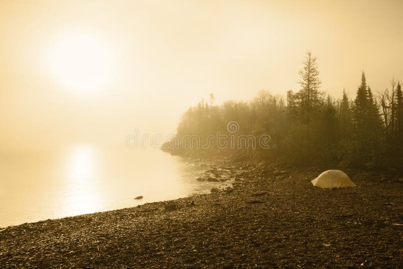 Accampandosi sulla spiaggia del lago Superiore ad alba fotografia stock libera da diritti Accampandosi sulla spiaggia del lago Superiore ad alba fotografia stock libera da diritti