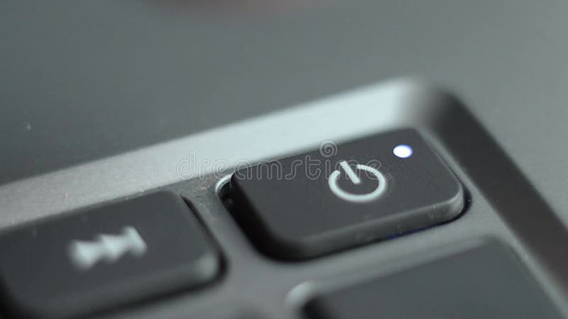 Accensione del notebook. il dito preme il pulsante di avvio sul computer.