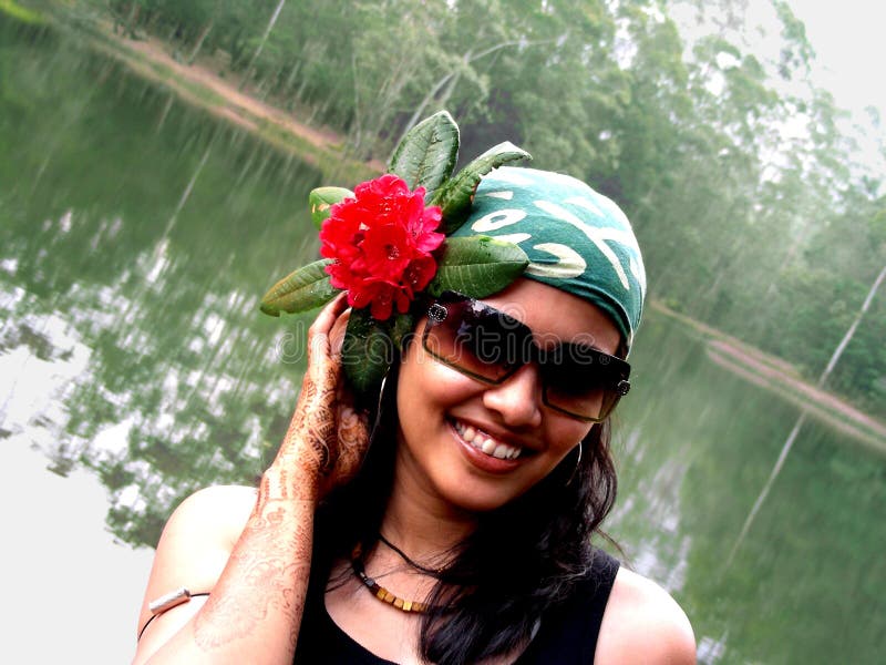 Accessarised Babe. An Indian babe using flower as a hair accessory standing by the lake royalty free stock photography