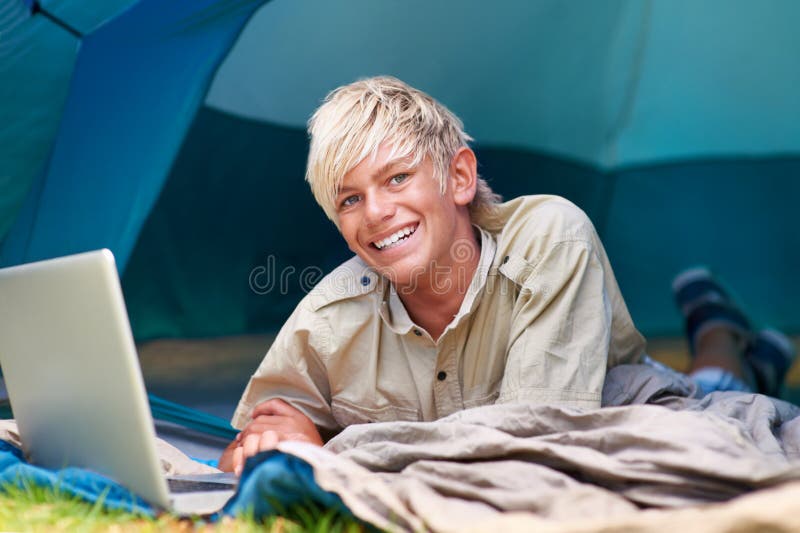 Accessing the while Camping in the Woods. Portrait of a Young Boy Surfing the  while