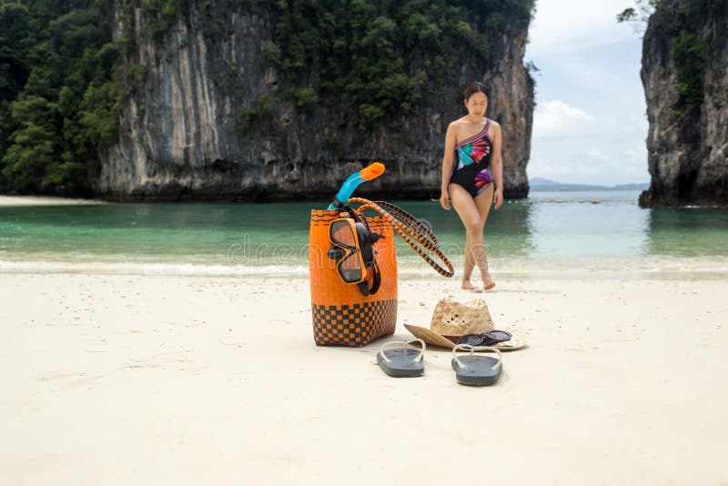 Accessoires de sac et de voyage de plage avec la femme à l'arrière-plan de tache floue des vacances images stock Accessoires de sac et de voyage de plage avec la femme à l'arrière-plan de tache floue des vacances images stock