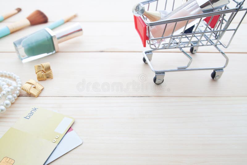 Accessoires et cosmétiques du ` s de femme dans le caddie avec le crédit c photo stock Accessoires et cosmétiques du ` s de femme dans le caddie avec le crédit c photo stock