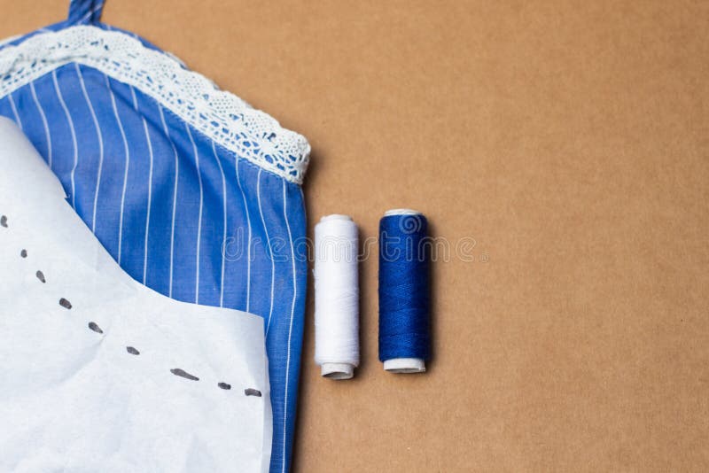 Accessori di cucito, pezzo di tessuto blu con pizzo, nastro di misurazione e filo colorato sul fondo della carta kraft Per il cuc immagine stock Accessori di cucito, pezzo di tessuto blu con pizzo, nastro di misurazione e filo colorato sul fondo della carta kraft Per il cuc immagine stock