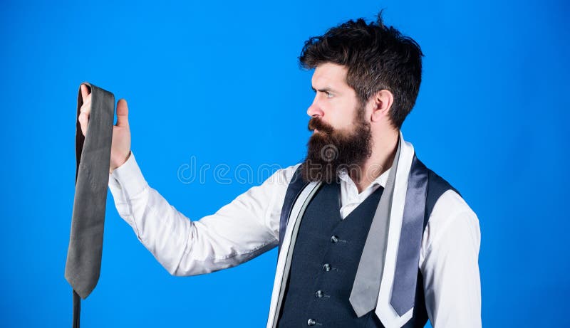 Accessory preserving the professional business look. Bearded man choosing menswear accessory. Businessman looking at luxury necktie accessory. Brutal caucasian man holding fashion accessory.
